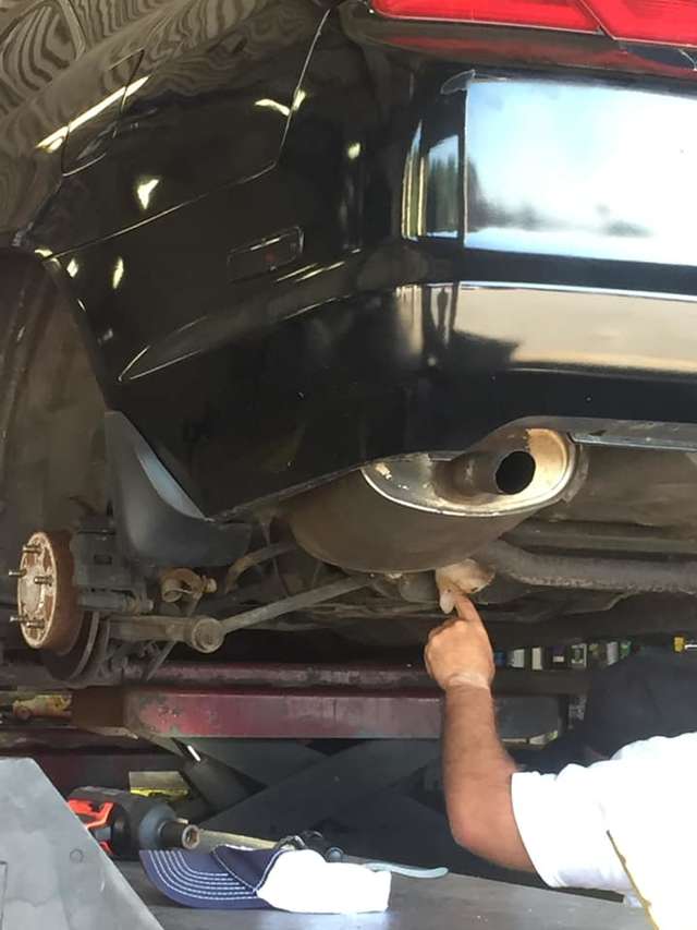 The cat was trying to crewel through the hole of the car located