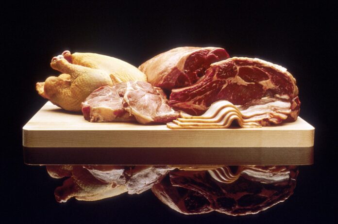 Raw chicken, beef and bacon on a wooden board, the kind of meat used i Raw chicken, beef and bacon on a wooden board, the kind of meat used in raw pet diets