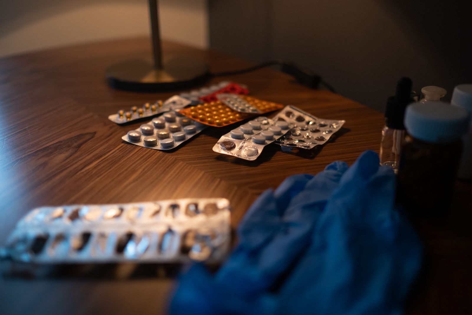 Blister packs of tablets on a table beside gloves
