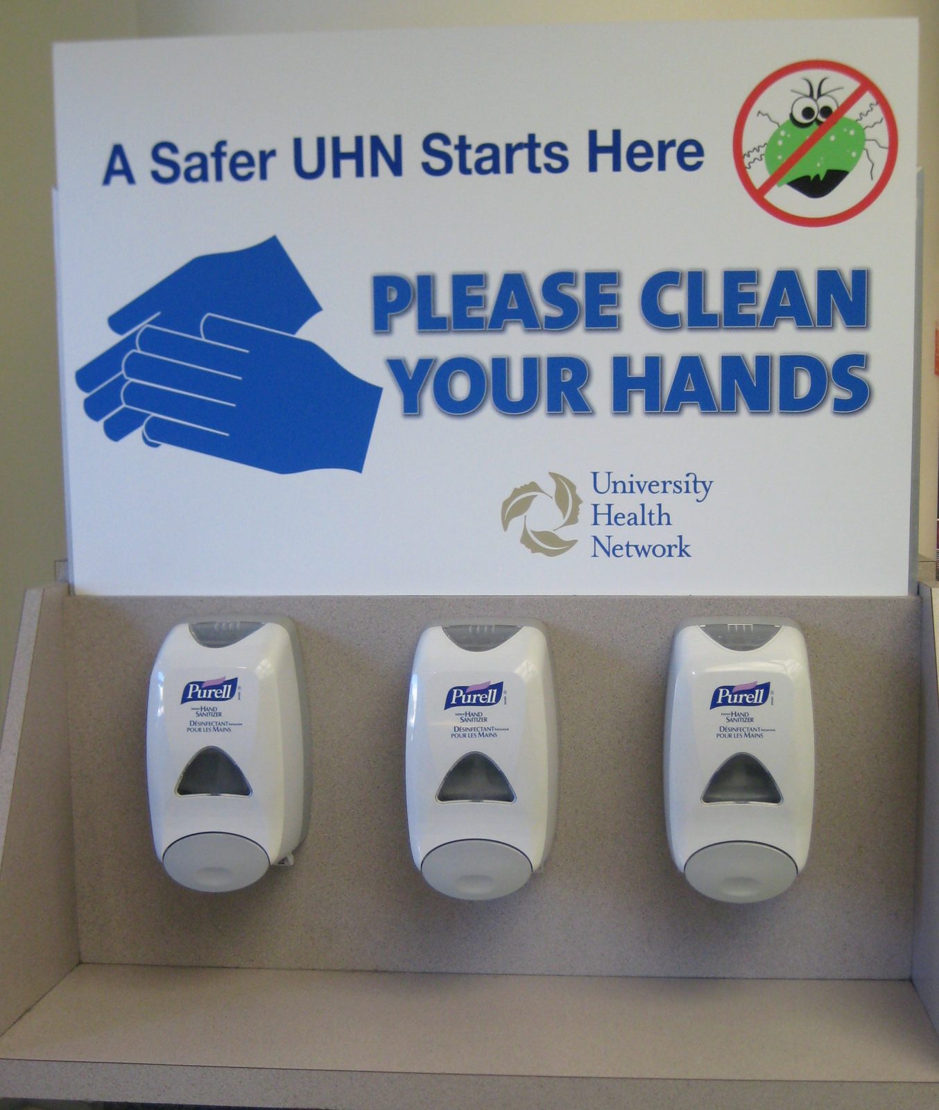 Hand sanitiser dispensers under a sign reading please clean your hands